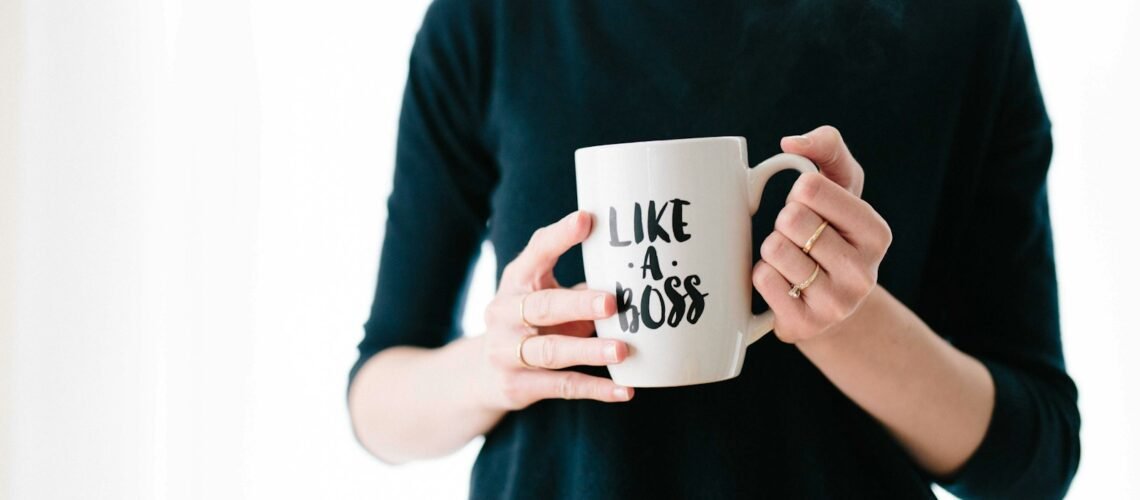 woman holding white mug while standing