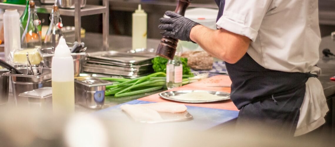 man putting herb on food